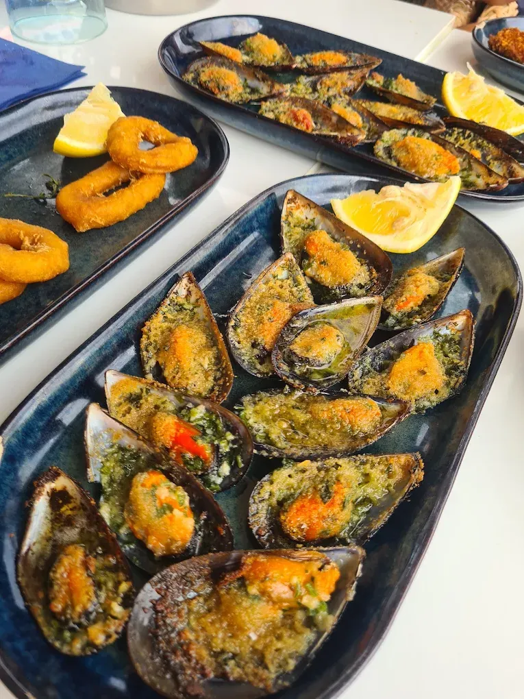 Moules gratinées et calamars frits sur plats bleus